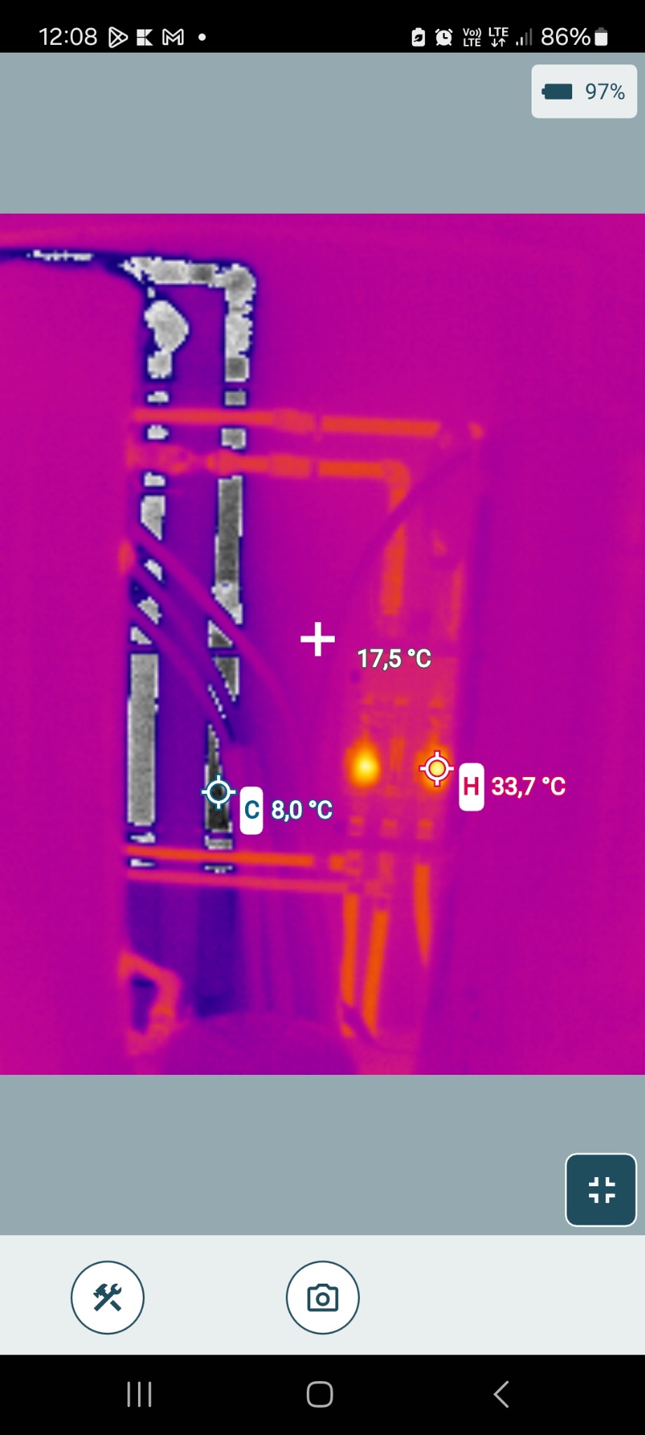 Termowizyjne zdjęcie instalacji grzewczej z zaznaczonymi temperaturami rur. Widoczne różnice temperatur wskazują na potencjalne straty ciepła lub nieprawidłowości w działaniu.