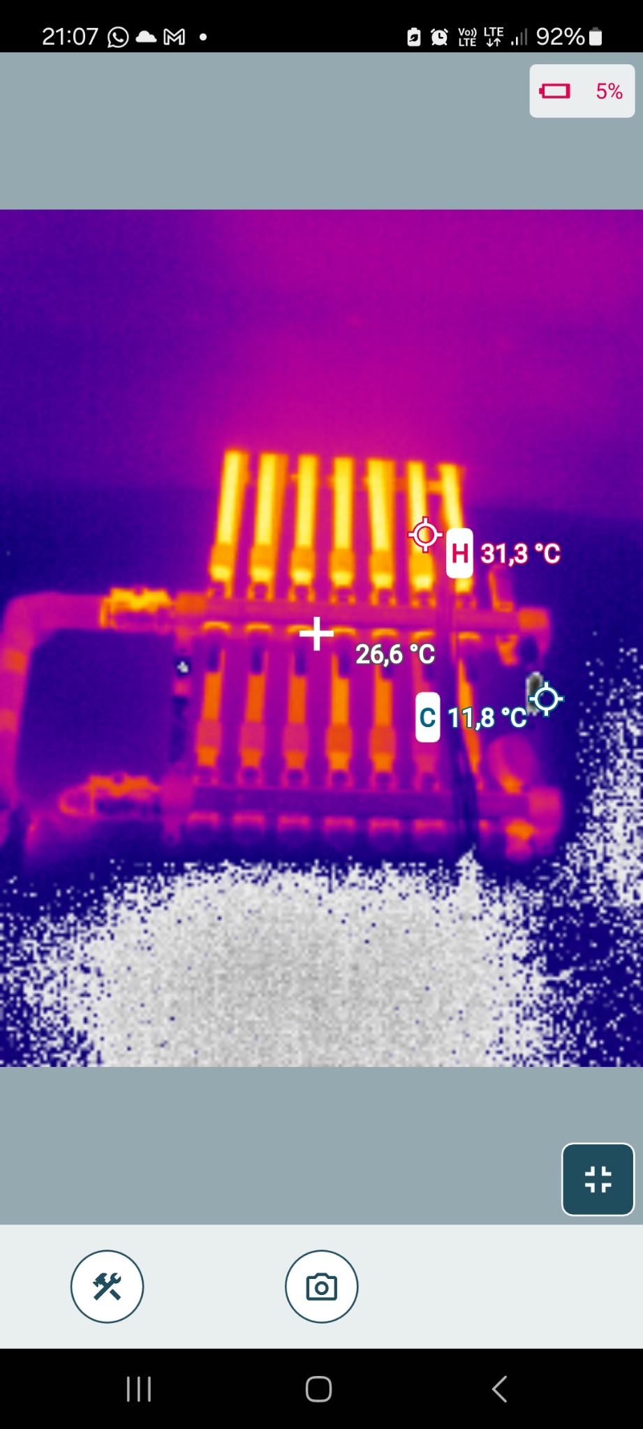 Termowizyjne badanie rozkładu temperatur na grzejniku, z zaznaczonymi punktami pomiarowymi i wartościami temperatur w stopniach Celsjusza. Widoczne rury i żebra grzejnika.