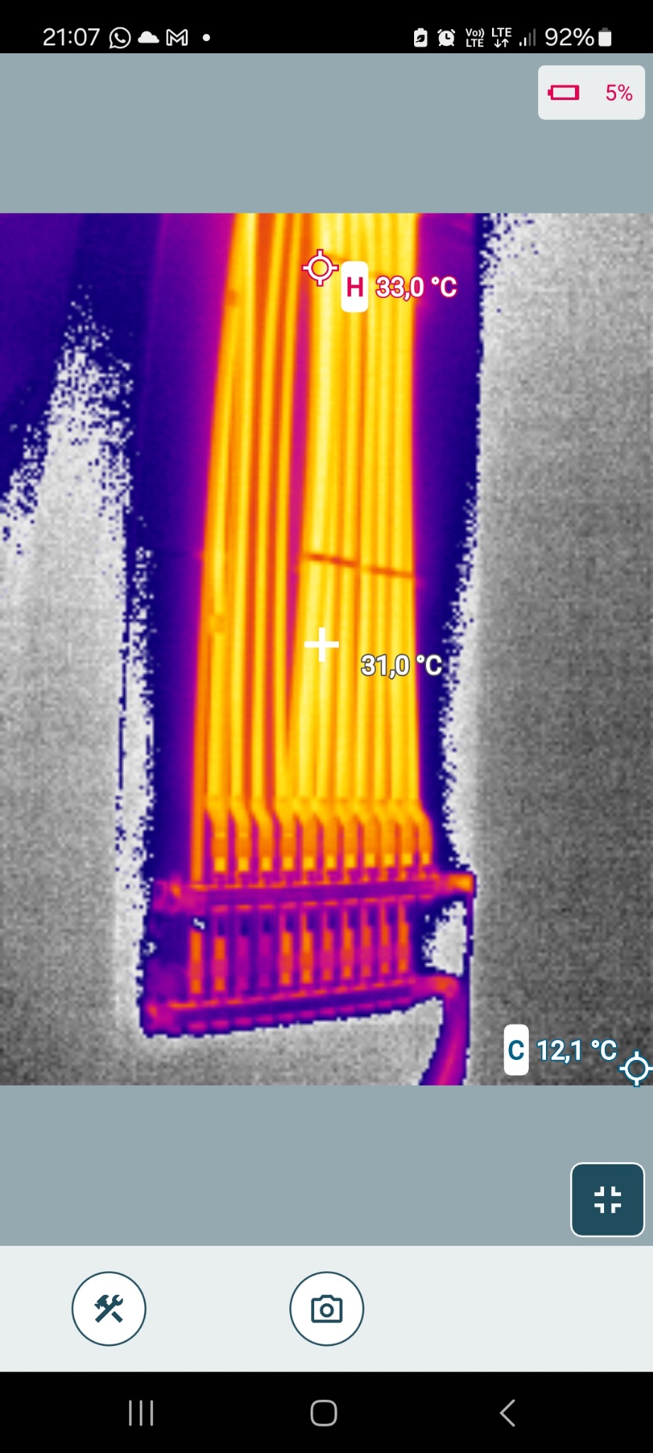 Termowizja rur ogrzewania podłogowego, ukazująca rozkład temperatur. Widoczne wartości 33°C i 31°C. Obraz z kamery termowizyjnej w odcieniach fioletu, żółci i szarości.