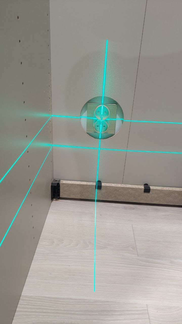 Montaż szafki z wyciętym otworem na gniazdko elektryczne, wyznaczanie poziomu laserem krzyżowym.