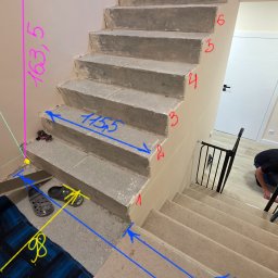 Kamień i Wnętrza - Surowe betonowe schody w trakcie budowy z naniesionymi odręcznie wymiarami, widoczne przygotowane stopnie na wyższym poziomie i prowizoryczne wykończenie.