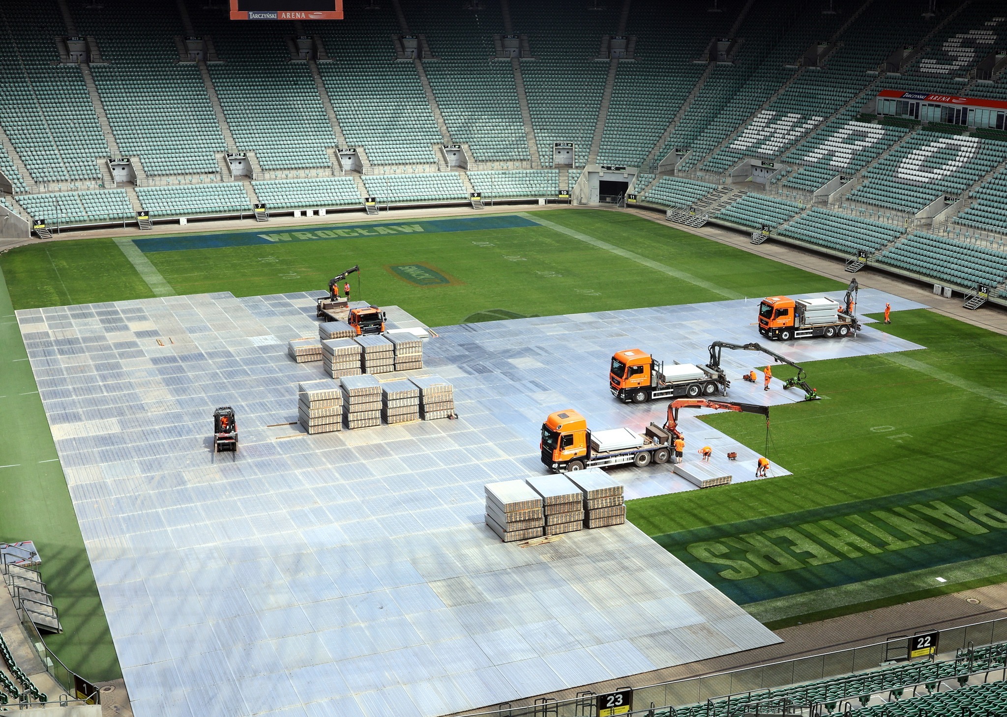 Zabezpieczenie płyty stadionu Tarczyński Arena we Wrocławiu przed koncertem Dawida Podsiadło