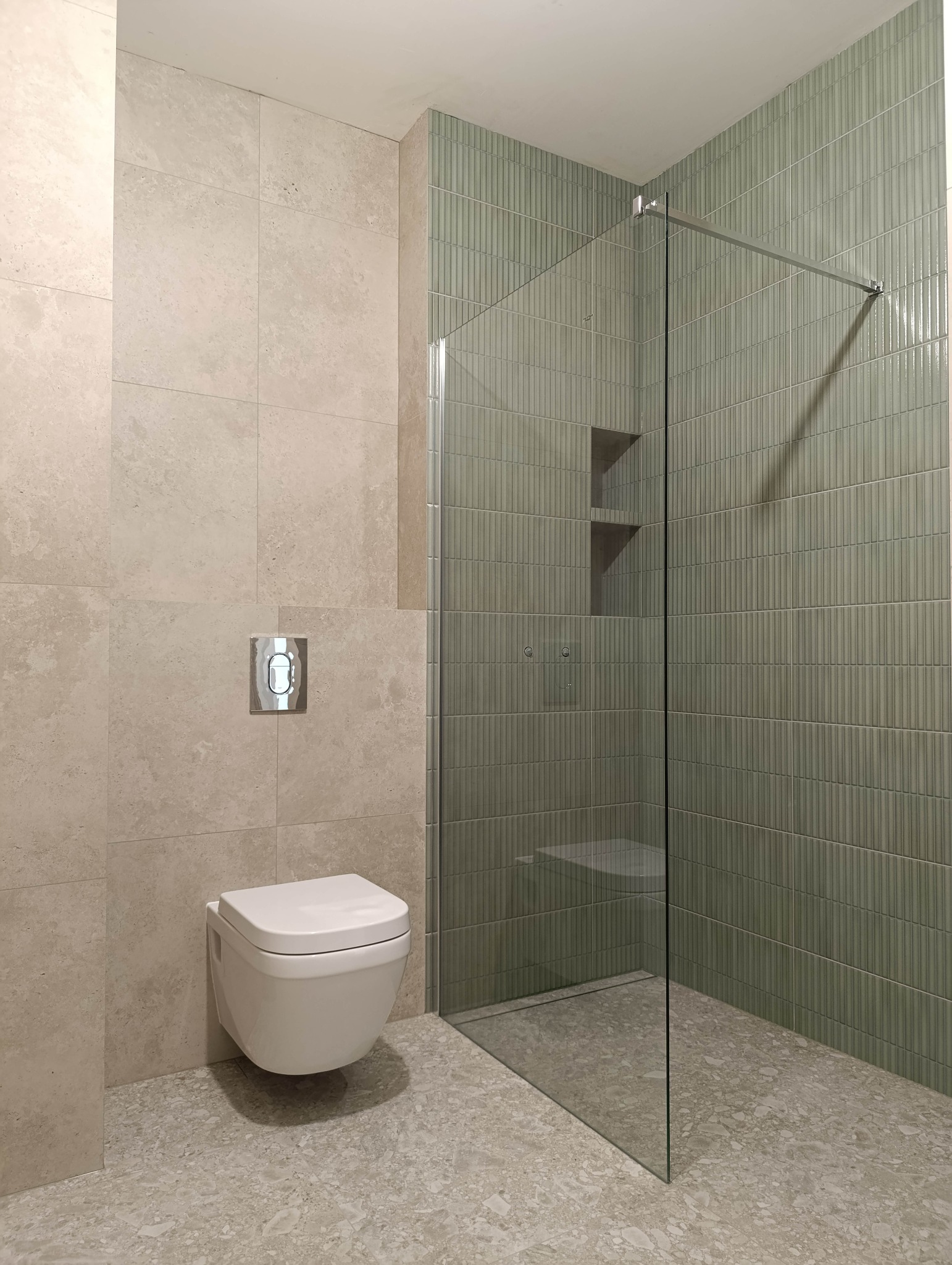 Nowoczesna łazienka z podwieszaną toaletą i kabiną walk-in, wykończona w beżach i zieleniach. Realizacja z Poznania.