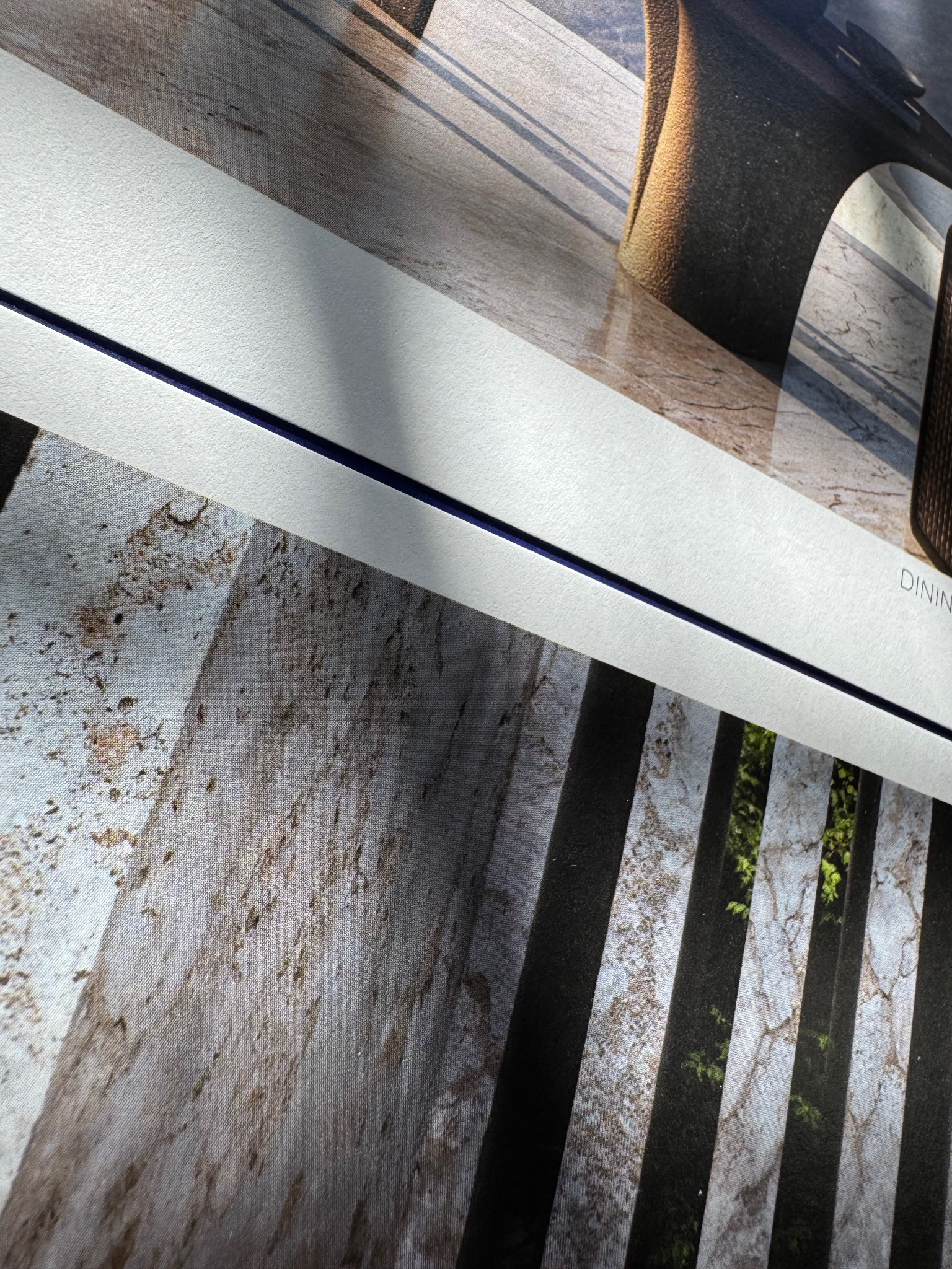 Fragment wydrukowanej ulotki z widoczną fakturą papieru Olin, prezentująca aranżację wnętrza z elementami dekoracyjnymi.