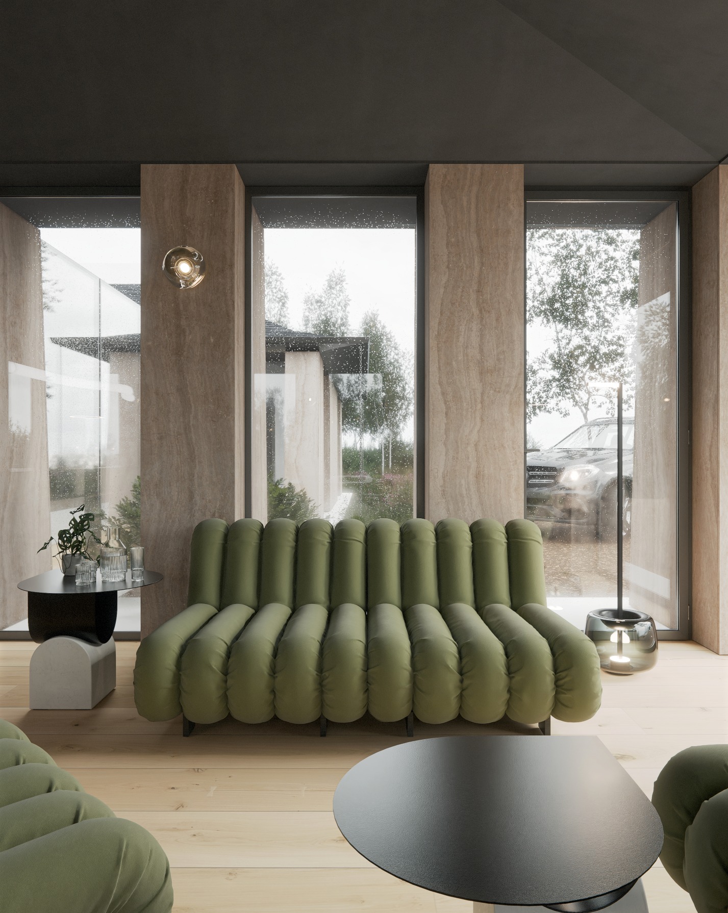 Wnętrze salonu z zieloną sofą w stylu retro, okrągłym stolikiem kawowym i dużymi oknami z widokiem na deszczowy ogród i samochód.