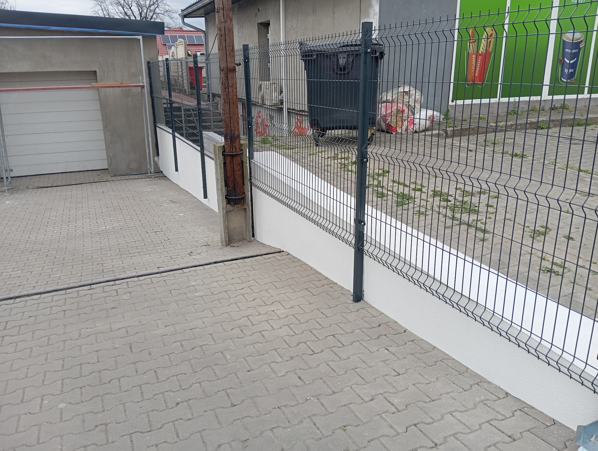 Montaż słupków na murze oporowym