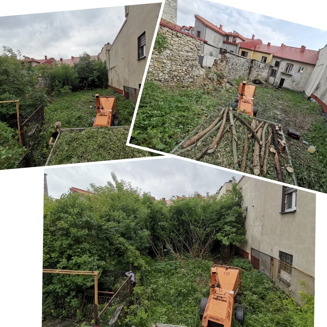 Podwórko po wycince drzew i krzewów, z pomarańczową rębarką do gałęzi, stos pociętych gałęzi, widoczna osoba przy pracy, otoczenie zabudowy miejskiej.