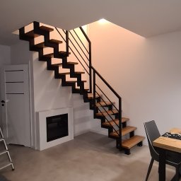 Z.P.H.U KRZYSZTOF LEJMAN - Nowoczesne schody metalowe z drewnianymi stopniami w jasnym wnętrzu z kominkiem elektrycznym i stołem