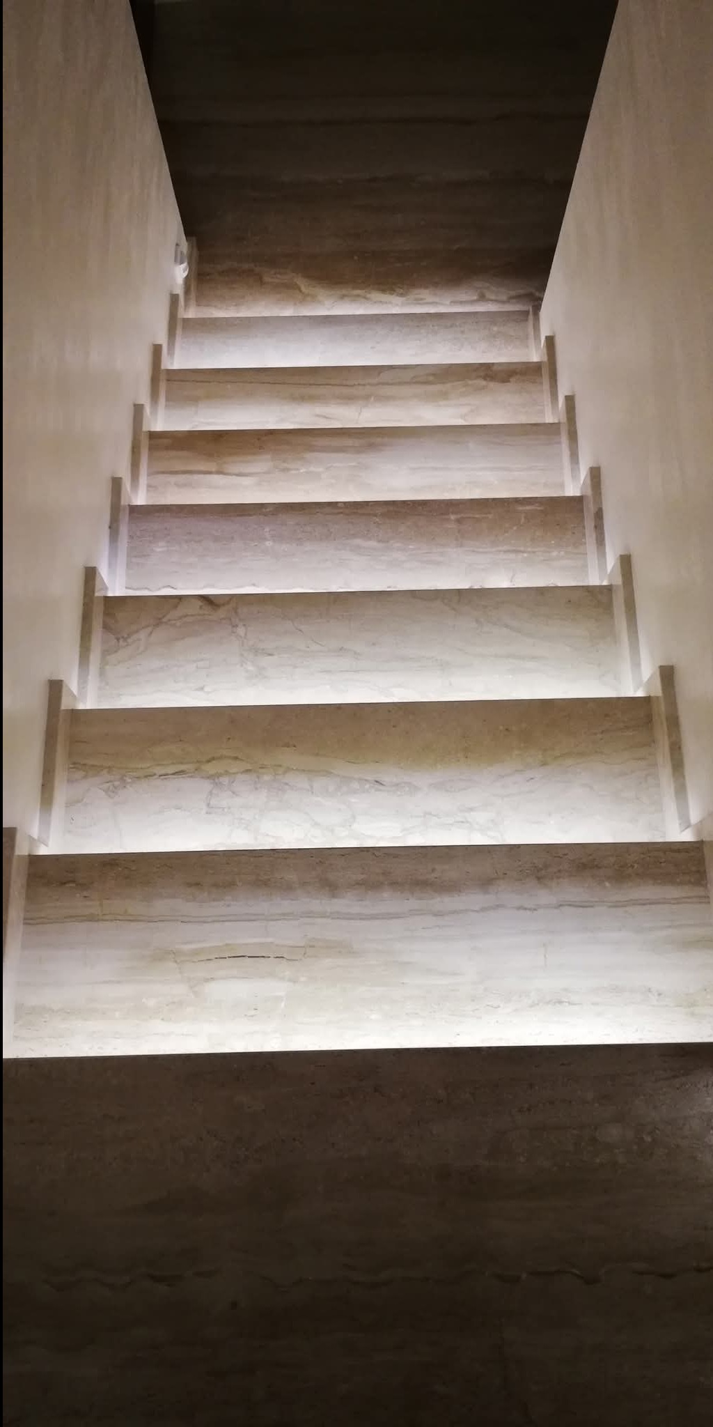 Schody z marmuru trawertynowego z podświetleniem LED pod każdym stopniem, widok z góry.