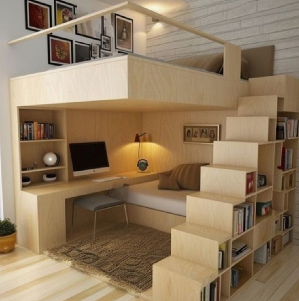 Wielofunkcyjna przestrzeń mieszkalna z łóżkiem na antresoli, biurkiem i schodami z półkami na książki, oświetlona lampką biurkową i światłami LED, utrzymana w jasnej kolorystyce drewna.