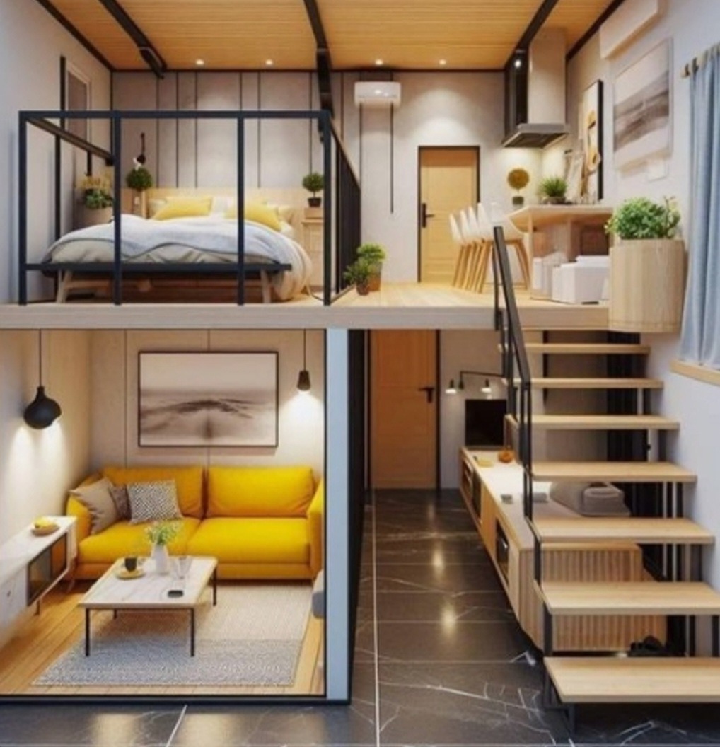 Dwupoziomowe mieszkanie z antresolą: sypialnia na górze z czarną balustradą, poniżej salon z żółtą sofą i obrazem nad nią, obok schody z drewnianymi stopniami i czarnymi poręczami.