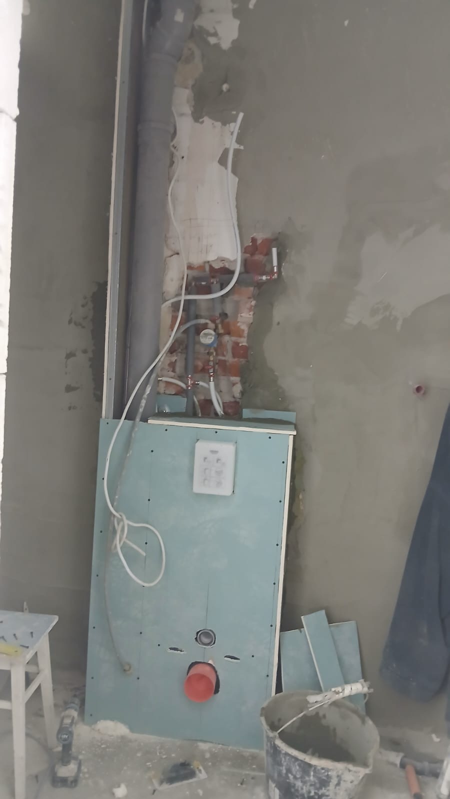 Montaż stelaża podtynkowego w łazience, widoczne rury, instalacja wodna i kanalizacyjna, ściany w trakcie wykończenia, przygotowanie do zabudowy płytami gipsowymi.