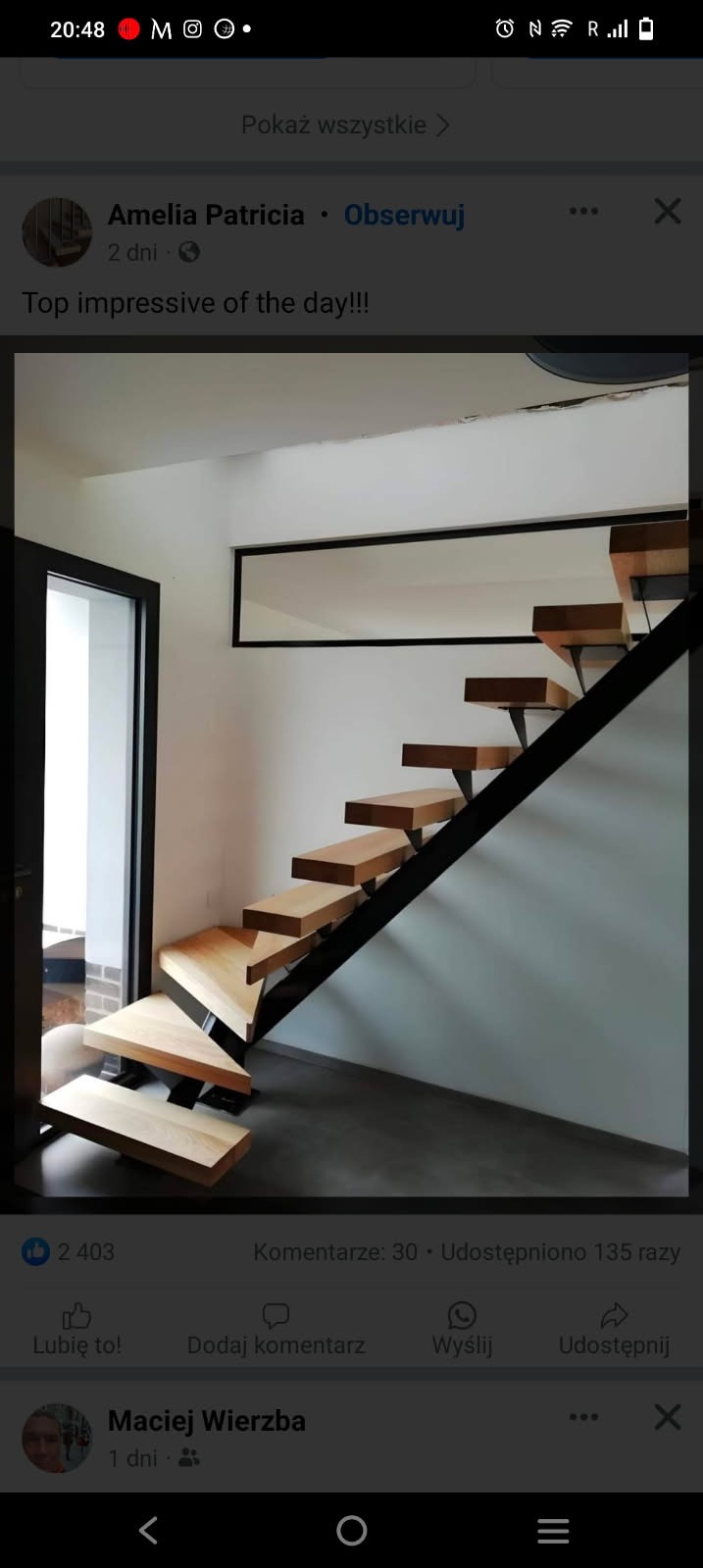 Nowoczesne schody z drewnianymi stopniami i czarną metalową konstrukcją, widoczne z dołu, z oknem w tle.