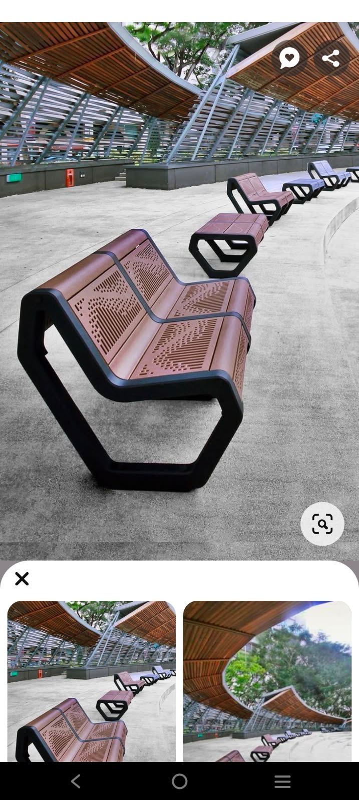 Rząd nowoczesnych, ażurowych ławek parkowych z brązowego drewna i czarnych metalowych ram, ustawionych wzdłuż ścieżki pod zadaszeniem z drewnianych listew.