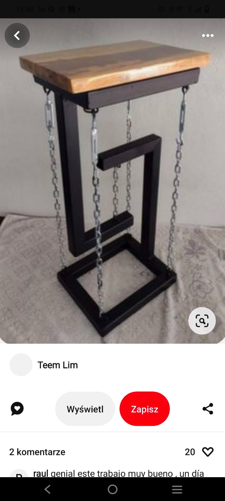 Nietypowy stolik kawowy z drewnianym blatem i metalową ramą, połączony łańcuchami, tworzący iluzję lewitacji.