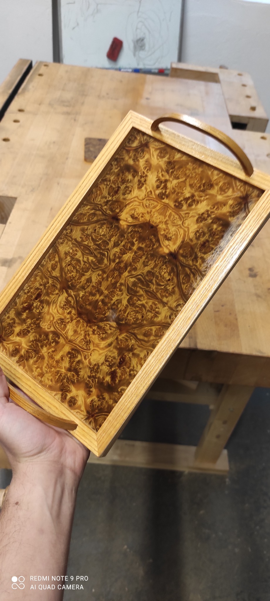 Lakierowana taca z drewna z uchwytami, wykonana w Borkach Wielkich, prezentująca unikalny wzór słojów drewna na blacie roboczym.