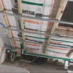 Sufit poddasza w trakcie izolacji, widoczne drewniane belki, profile metalowe i folia paroizolacyjna Eurovent Clima X. Przewody elektryczne leżące na podłodze.