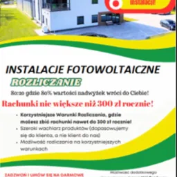 Reklama firmy oferującej instalacje fotowoltaiczne i rozliczanie energii, z budynkiem firmy w tle i hasłem 'Korzystniejsze rozliczanie instalacji!'