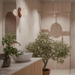 sueños studio - Beżowa łazienka z umywalką nablatową, armaturą w kolorze miedzi, geometryczną grafiką na szklanej kabinie prysznicowej i drzewkiem oliwnym w donicy.