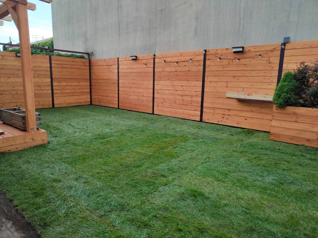 Budowa drewnianego ogrodzenia oraz założenie trawnika z rolki.