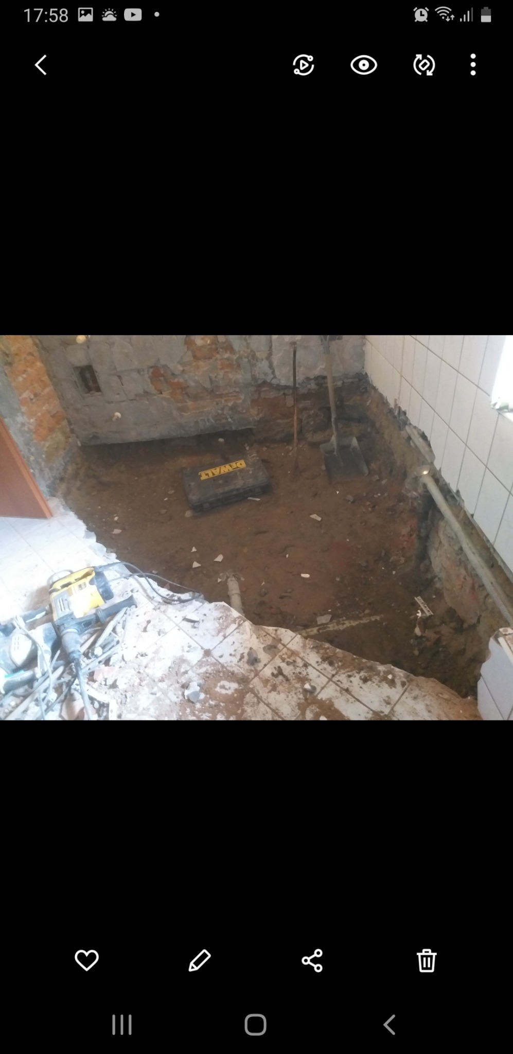 Demontaż podłogi w łazience, widoczny gruz, narzędzia,  kucie ścian i przygotowanie do dalszych prac remontowych.