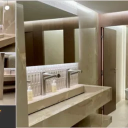 Elegancka łazienka w hotelu Marriott. Marmurowe umywalki, lustra z podświetleniem LED i kabiny WC z drewnianymi drzwiami tworzą luksusową przestrzeń.