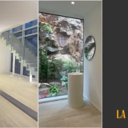 Nowoczesne wnętrze: minimalistyczne schody z szklaną balustradą i designerska łazienka z oknem na skałę. Elementy drewniane i beżowy marmur.