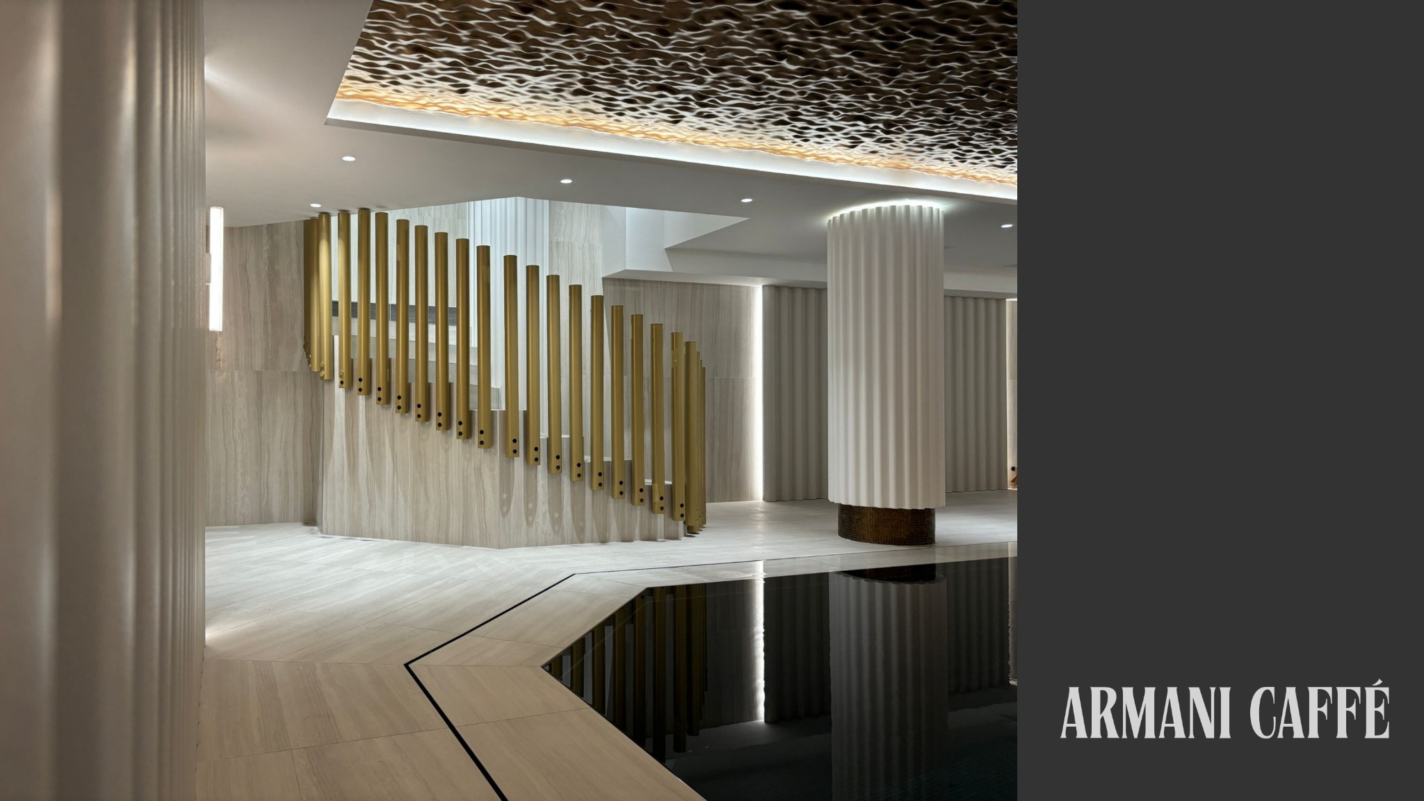 Eleganckie wnętrze: schody z złotymi balustradami, kolumna z żłobieniami i dekoracyjny sufit z oświetleniem. Minimalistyczny design z elementami luksusu.