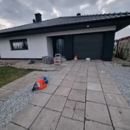 Dom jednorodzinny w Gledzianowie po częściowym malowaniu elewacji, widoczne przygotowane materiały, drabina i wiaderka z farbą.