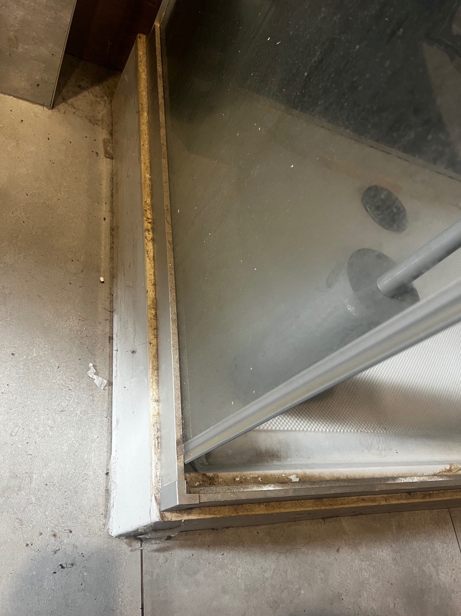 Zabrudzona kabina prysznicowa z widocznymi osadami i plamami, wymagająca dokładnego czyszczenia w Częstochowie. Widok z bliska na detale.