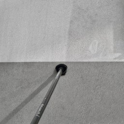 Czysta Sprawa 24 CLEAN CASE Sp. z o.o. - Ślad czystej powierzchni na ścianie po użyciu narzędzia z długim uchwytem, widoczny kontrast między czystym a brudnym obszarem.