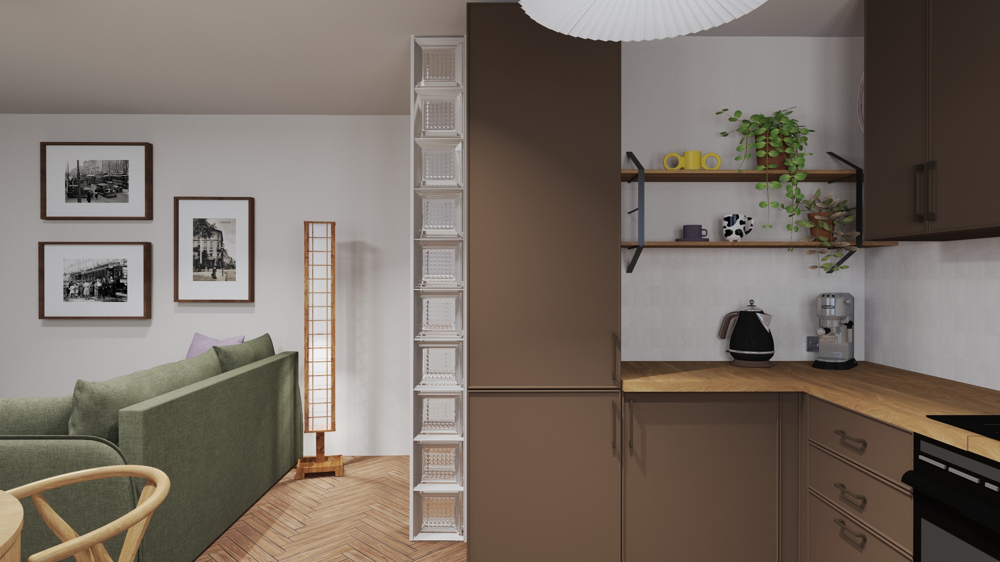 Projekt kuchni w mieszkaniu: brązowe szafki, drewniany blat, szklane luksfery obok szafki, salon w tle z grafikami na ścianie i parkietem w jodełkę.