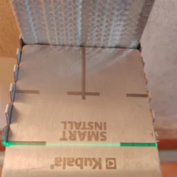 Metalowy profil sufitowy z narzędziem Kubala Smart Install, zielona linia lasera, zbliżenie na konstrukcję sufitu podwieszanego.