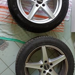 Studio Polerka - Dwa koła samochodowe z felgami aluminiowymi, jedno czyste i błyszczące, drugie zabrudzone. Widoczne detale bieżnika opony i wzór felgi.