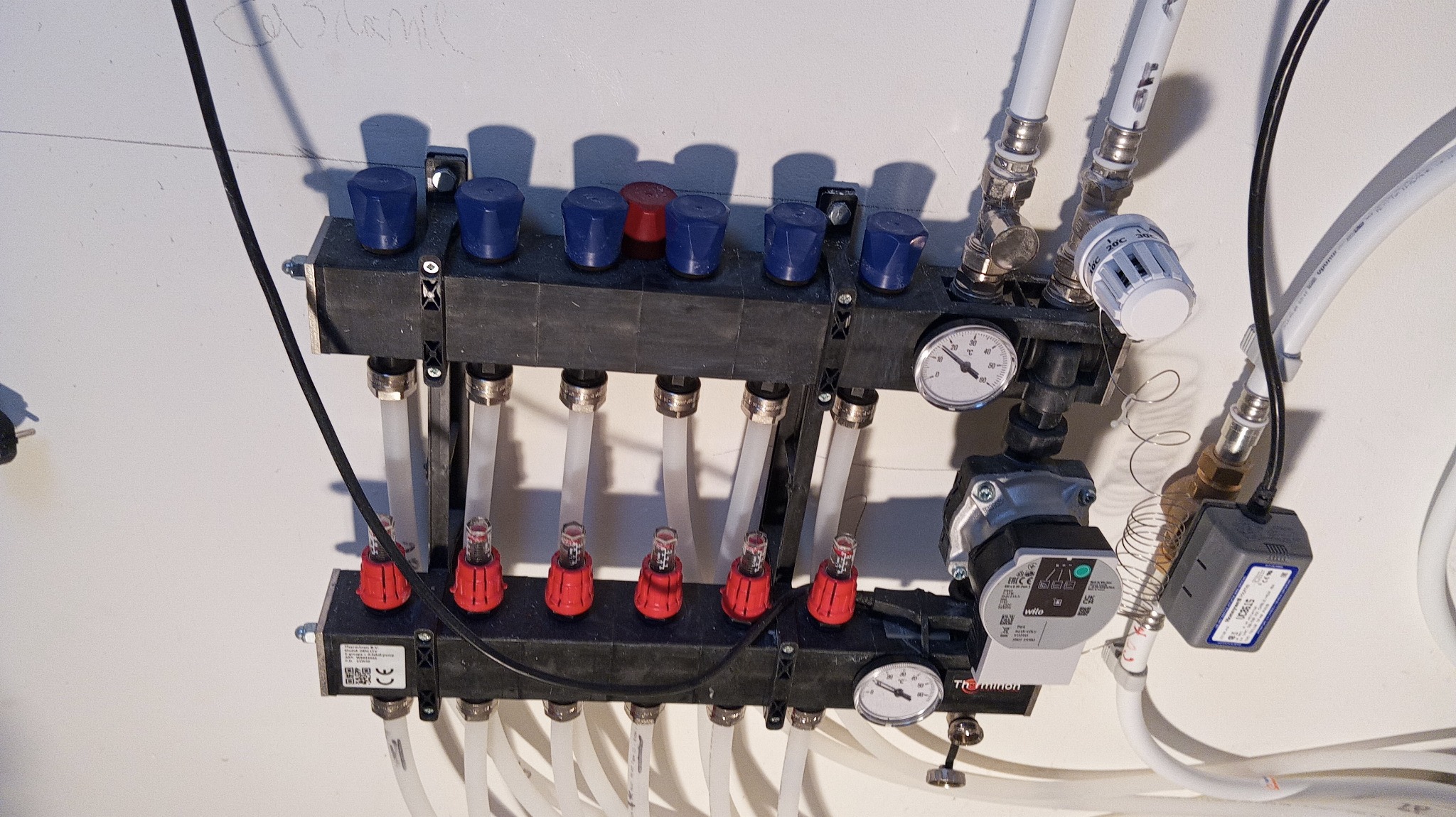 rozdzielacz ogrzewania podłogowego - po prawej stronie widoczny zawór sterowania na poszczególne piętra