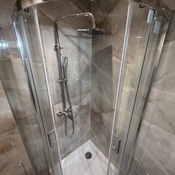 BART-BUD BARTOSZ ŁOŚ WYKOŃCZENIA WNĘTRZ - Nowoczesna kabina prysznicowa z deszczownicą, wykończona marmurowymi płytkami w odcieniach szarości i beżu. Chromowane detale podkreślają elegancję.