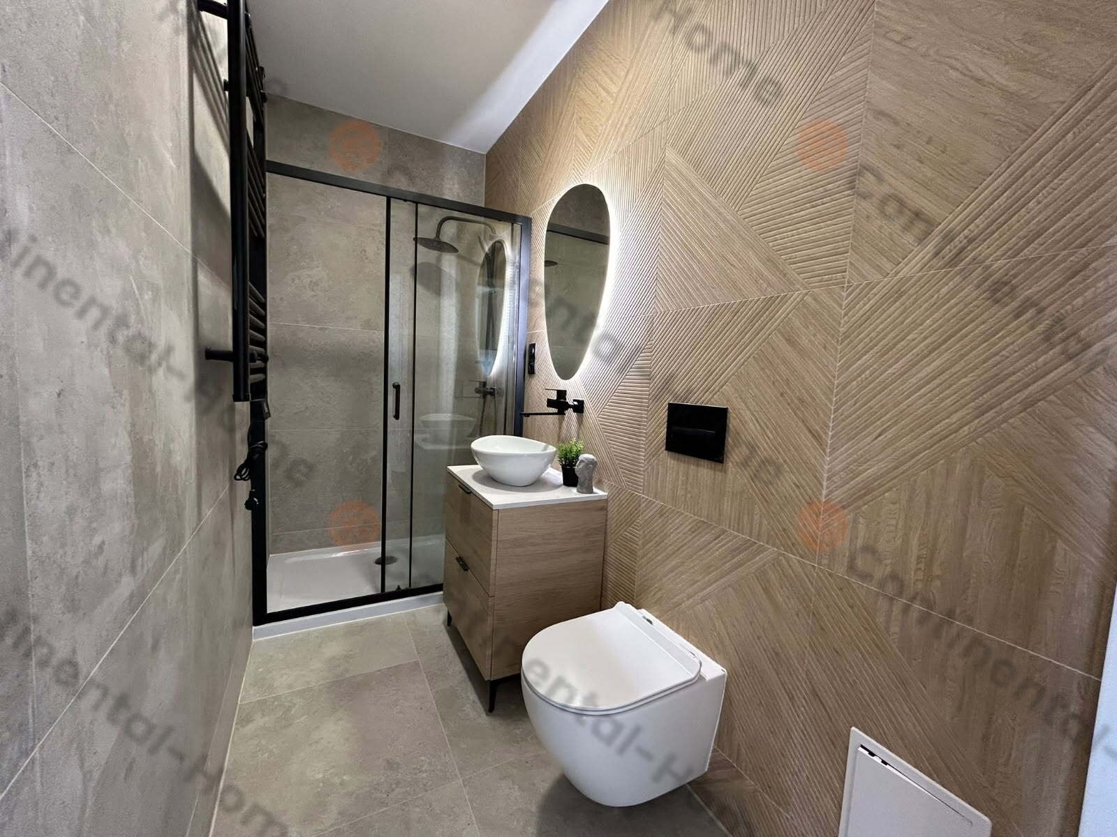 Nowoczesna łazienka z kabiną prysznicową w czarnej ramie, umywalką nablatową na drewnianej szafce, podświetlanym owalnym lustrem i toaletą podwieszaną; ściany wyłożone płytkami imitującymi drewno...
