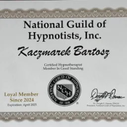 Certyfikat 'National Guild of Hypnotists, Inc.' dla Kaczmarka Bartosza, potwierdzający status certyfikowanego hipnoterapeuty, ważny do kwietnia 2025, z ozdobną ramką i pieczęcią.