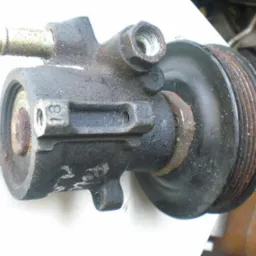 Używana pompa wspomagania układu kierowniczego z kołem pasowym, widoczne ślady eksploatacji i zabrudzenia.