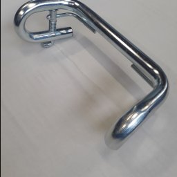 JAK-MET Jakubowski Dawid - Chromowana, gięta rura z mechanizmem sprężynowym, prawdopodobnie element balustrady lub poręczy, leżąca na jasnej powierzchni.