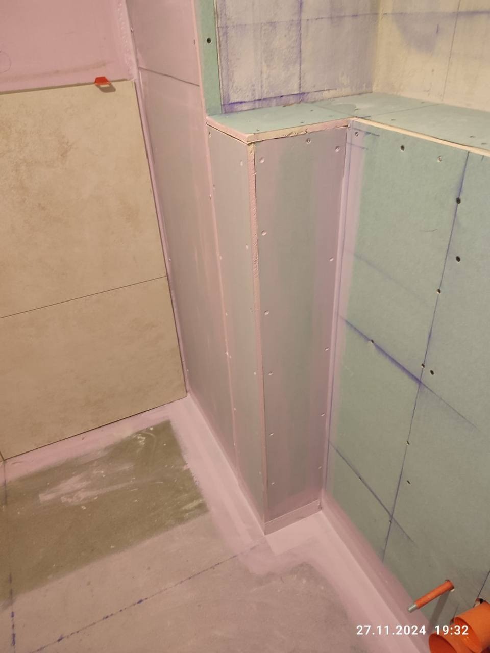 Montaż płyt gipsowo-kartonowych w narożniku łazienki, widoczne połączenia zabezpieczone masą uszczelniającą, przygotowanie do dalszych prac.