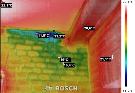 Termowizyjne badanie ściany z widocznymi obszarami o obniżonej temperaturze, wskazujące na potencjalne straty ciepła. Zaznaczone punkty pomiarowe z wartościami temperatury w stopniach Celsjusza.