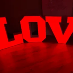 Duże, czerwone, podświetlane litery tworzące słowo 'LOVE' na błyszczącej podłodze, z delikatnym napisem 'Better Together' widocznym w tle.