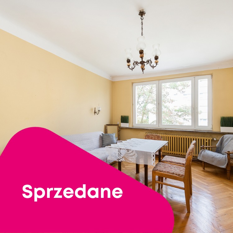 Salon z meblami w stylu retro, oświetlony przez okno i żyrandol, z nakładką graficzną 'Sprzedane'.