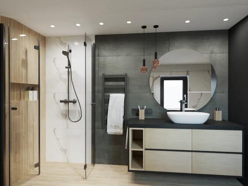 Nowoczesna łazienka z kabiną prysznicową typu walk-in, okrągłym lustrem, umywalką nablatową i drewnopodobnymi płytkami na podłodze, oświetlona trzema wiszącymi lampami z miedzianymi akcentami.