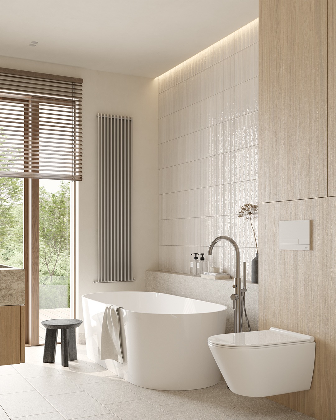 Jasna łazienka z wolnostojącą wanną, wiszącą toaletą i grzejnikiem żeberkowym przy oknie z żaluzjami, minimalistyczny stołek obok wanny, ściany wykończone płytkami w odcieniach beżu i drewnianą...