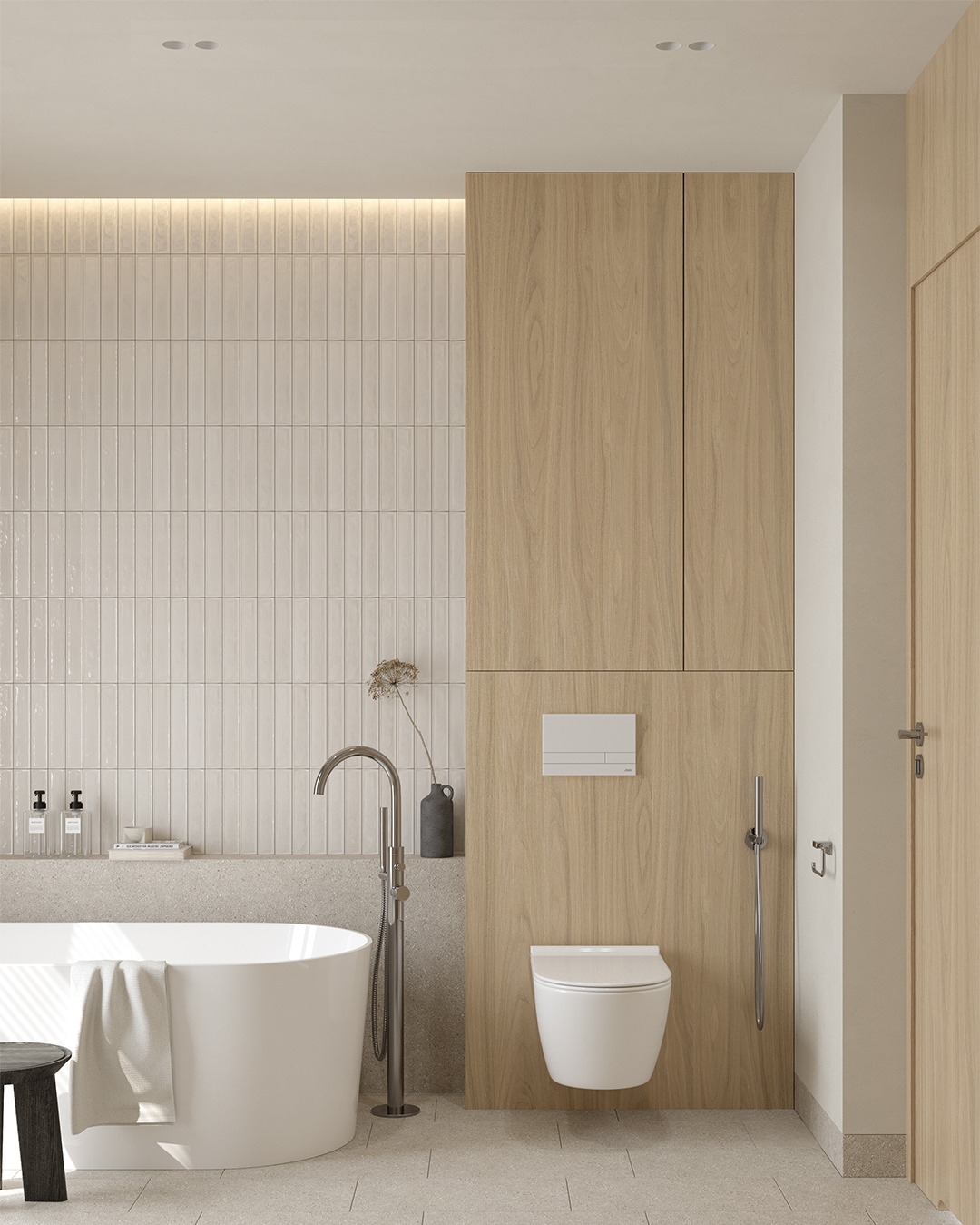 Nowoczesna łazienka z wolnostojącą wanną, beżowymi płytkami pionowymi, drewnianą zabudową i toaletą podwieszaną, uzupełniona minimalistyczną dekoracją.
