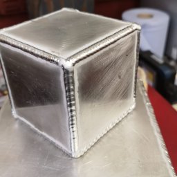 13th Welding Garage - Dwa aluminiowe, spawane prostopadłościany, jeden na drugim, z widocznymi śladami obróbki i spoinami