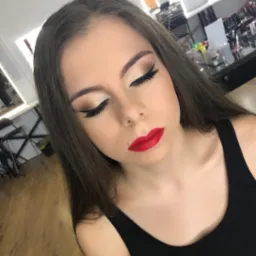 Portret kobiety z zamkniętymi oczami, prezentującej profesjonalnie wykonany, wieczorowy make-up: złote cienie z czarną kreską i intensywnie czerwone usta.