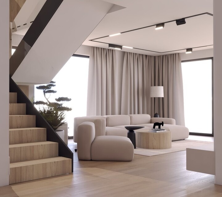 Nowoczesny salon w Sokołowie Małopolskim z minimalistycznymi schodami drewnianymi, beżową sofą modułową, okrągłym stolikiem kawowym i oświetleniem szynowym. W tle widoczna roślina w donicy.